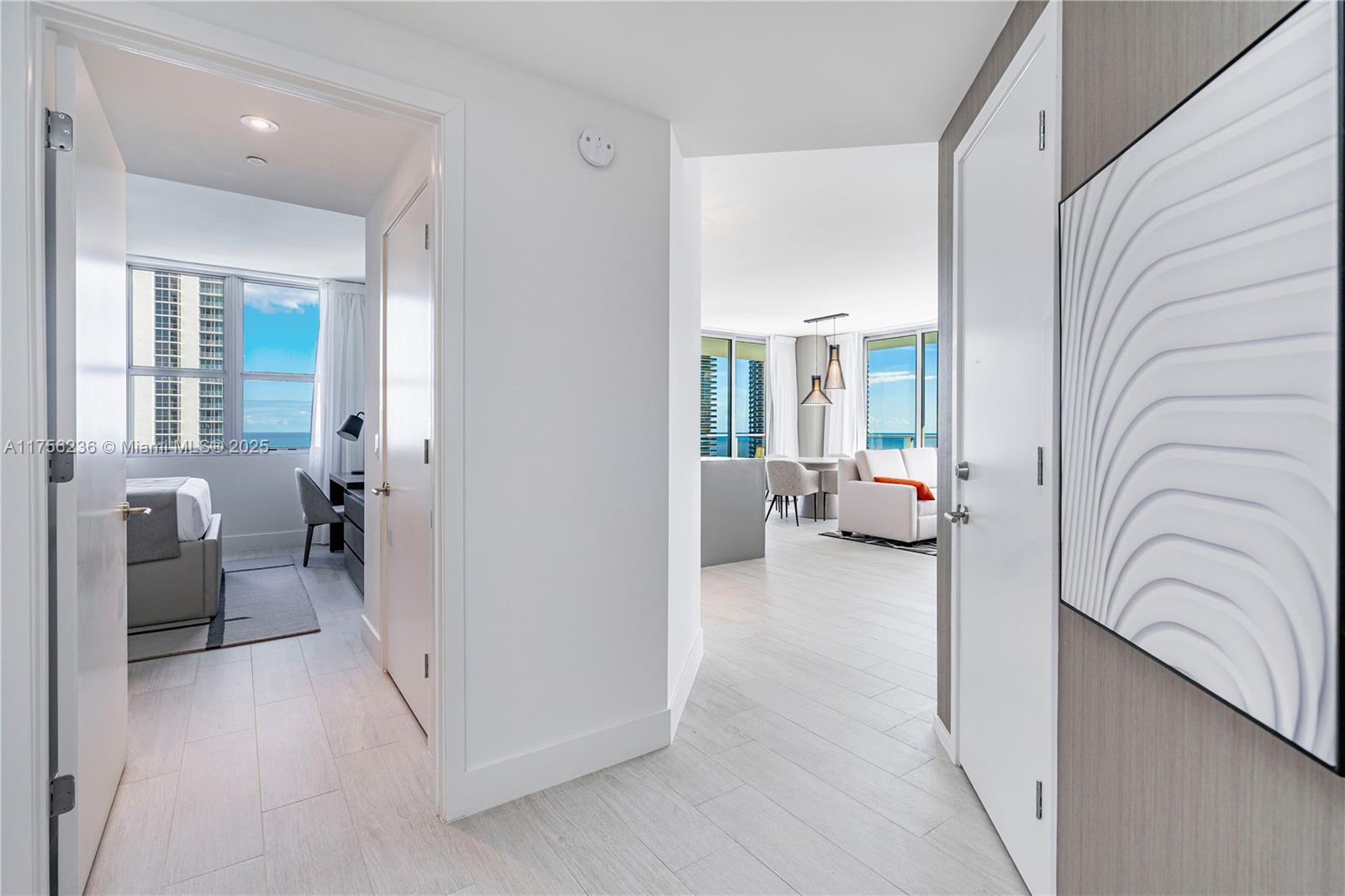 A bright hallway leads to a bedroom on the left and a living area beyond — 4010 S Ocean Dr # R1609, Hollywood FL 33019, HOLLYWOOD, FL