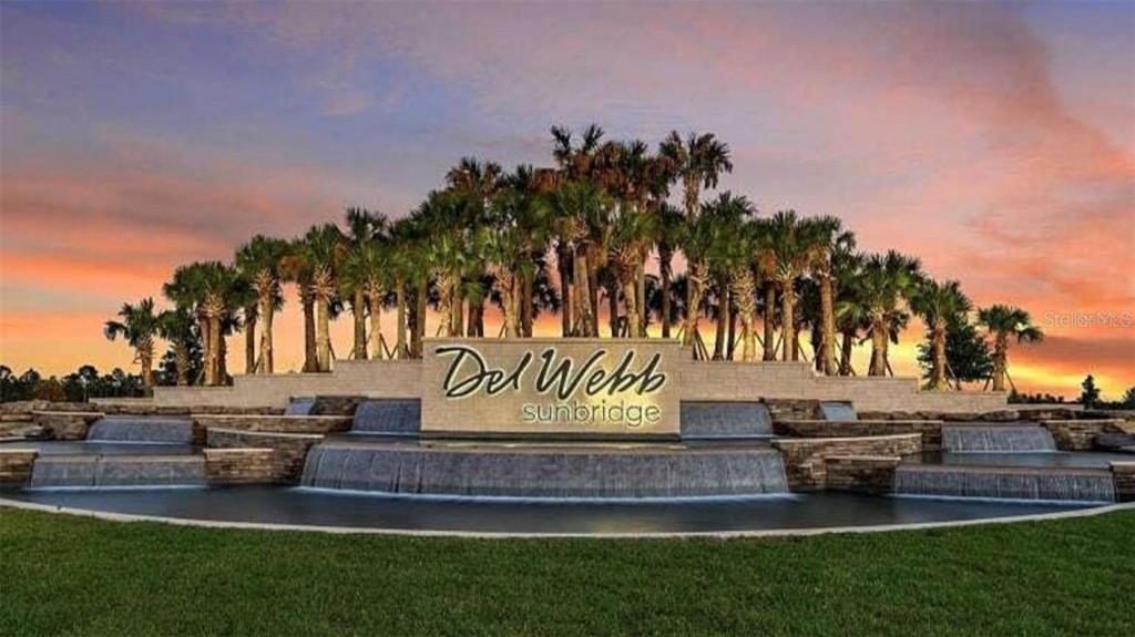 A stone monument sign for Del Webb Sunbridge sits before a tiered water feature and palms — 6354 SHIMMERING SHORES LANE, ST CLOUD, FL