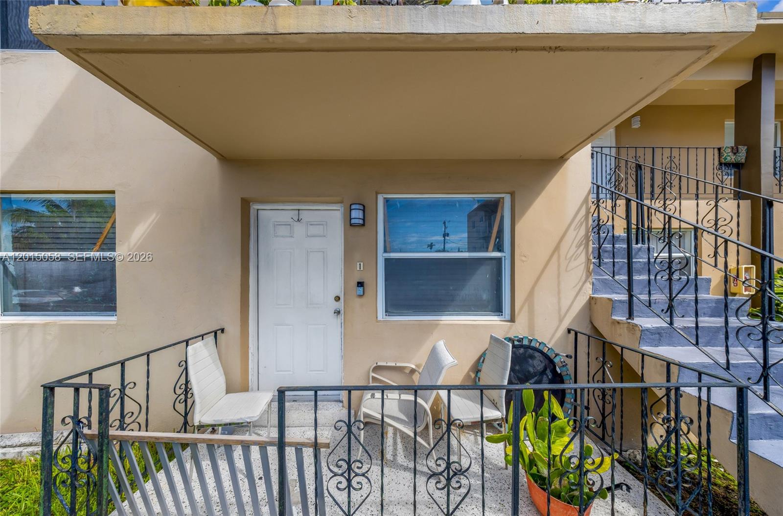 A ground-level apartment entrance features a white door, a window, and a small patio — 225 SW 18th Ave, Miami FL 33135, MIAMI, FL