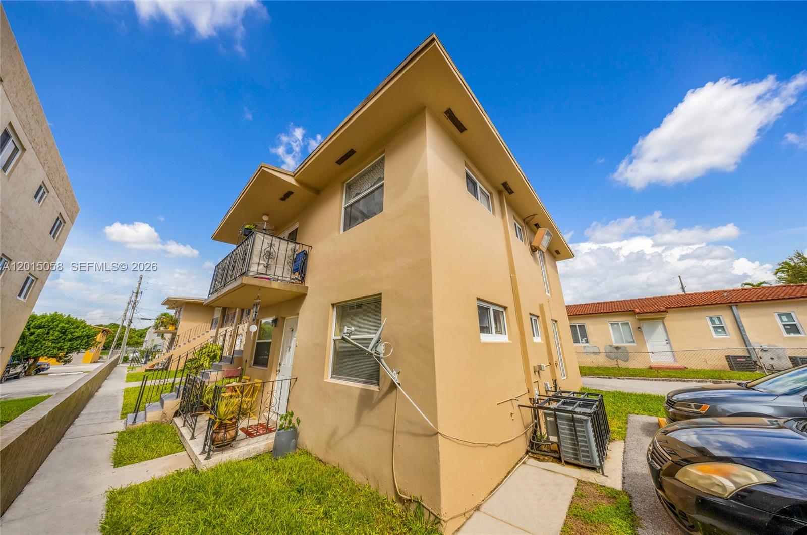 A two-story tan apartment building with a balcony and a parking area — 225 SW 18th Ave, Miami FL 33135, MIAMI, FL