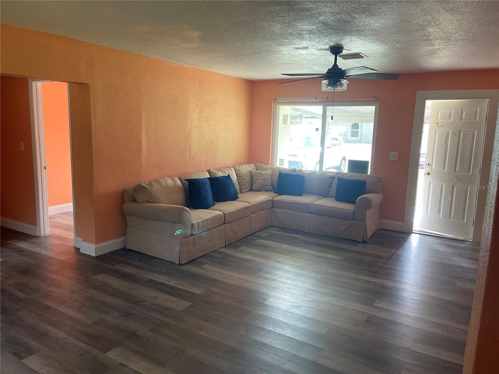 A room with white walls, gray wood-look flooring, a ceiling fan, and multiple windows — 1701 36TH STREET NW, WINTER HAVEN, FL