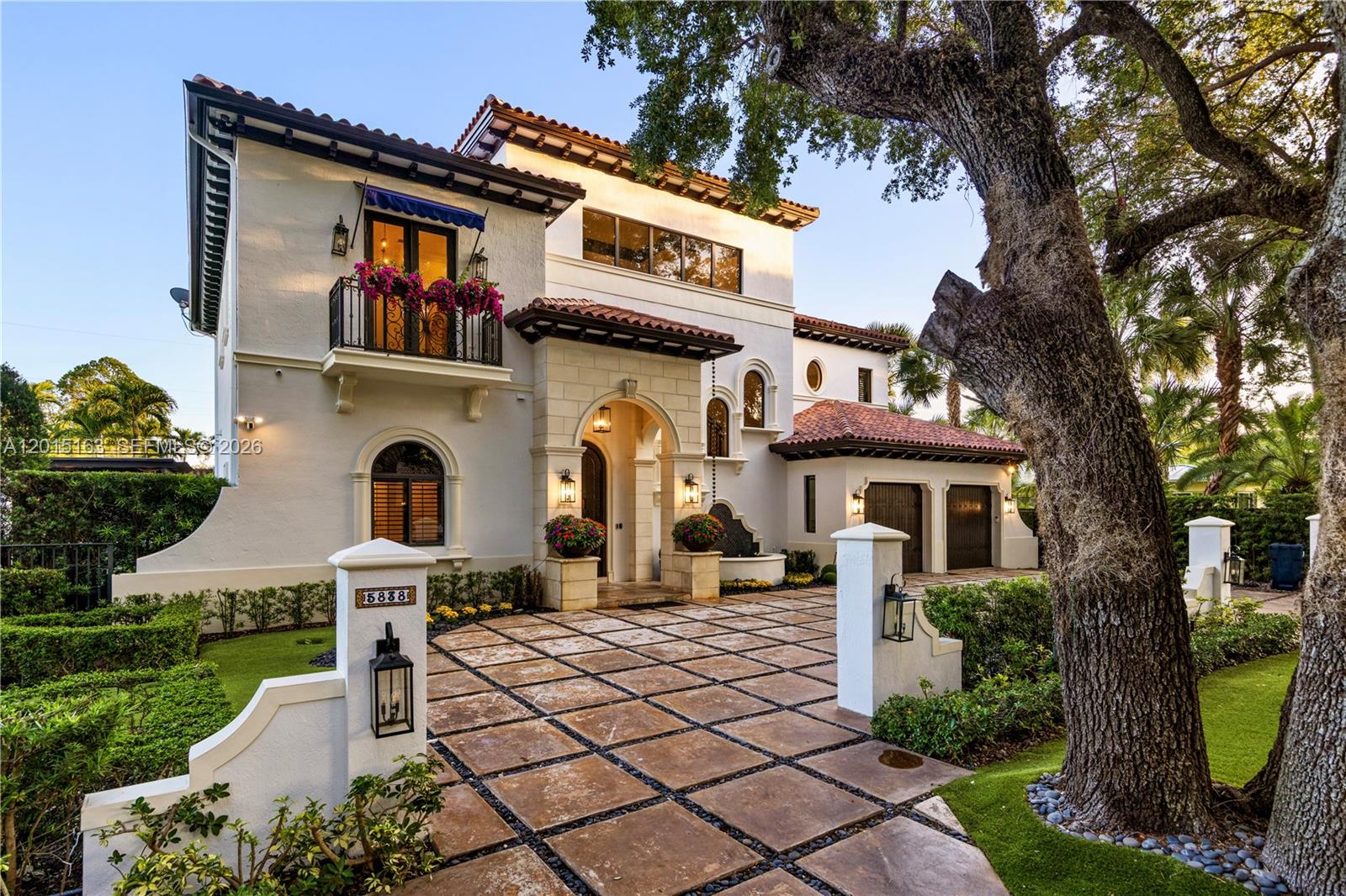 A two-story Mediterranean-style house features a tiled roof, a stone arched entryway, and a paved driveway — 5838 SW 50th St, Miami FL 33155, MIAMI, FL