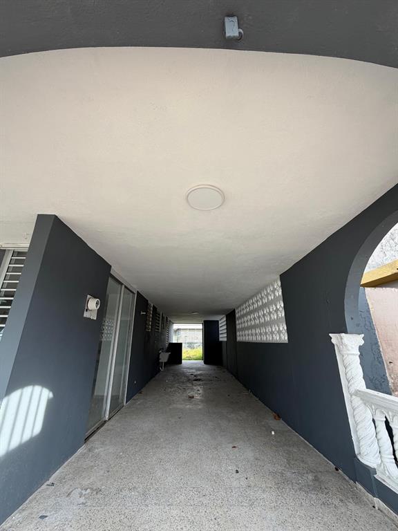A covered outdoor walkway features gray walls, a white ceiling, and a concrete floor — Villa Carolina 205-13 N 510, CAROLINA, PR