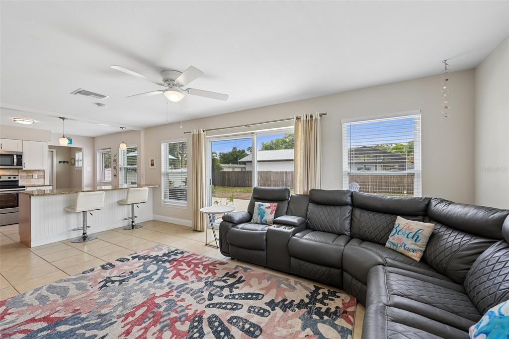 A living room features a large gray sectional sofa, a patterned rug, and a kitchen island — 5005 BEE RIDGE ROAD, SARASOTA, FL