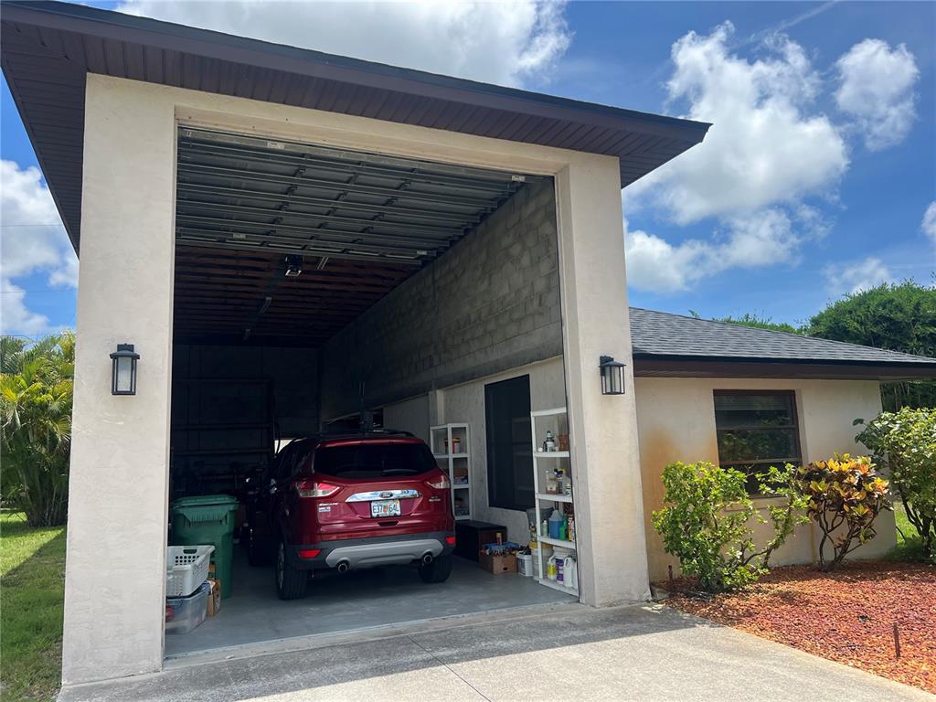 A single-story house with a stone-accented garage, palm trees, and a landscaped front yard — 9438 CRUGAR, ENGLEWOOD, FL