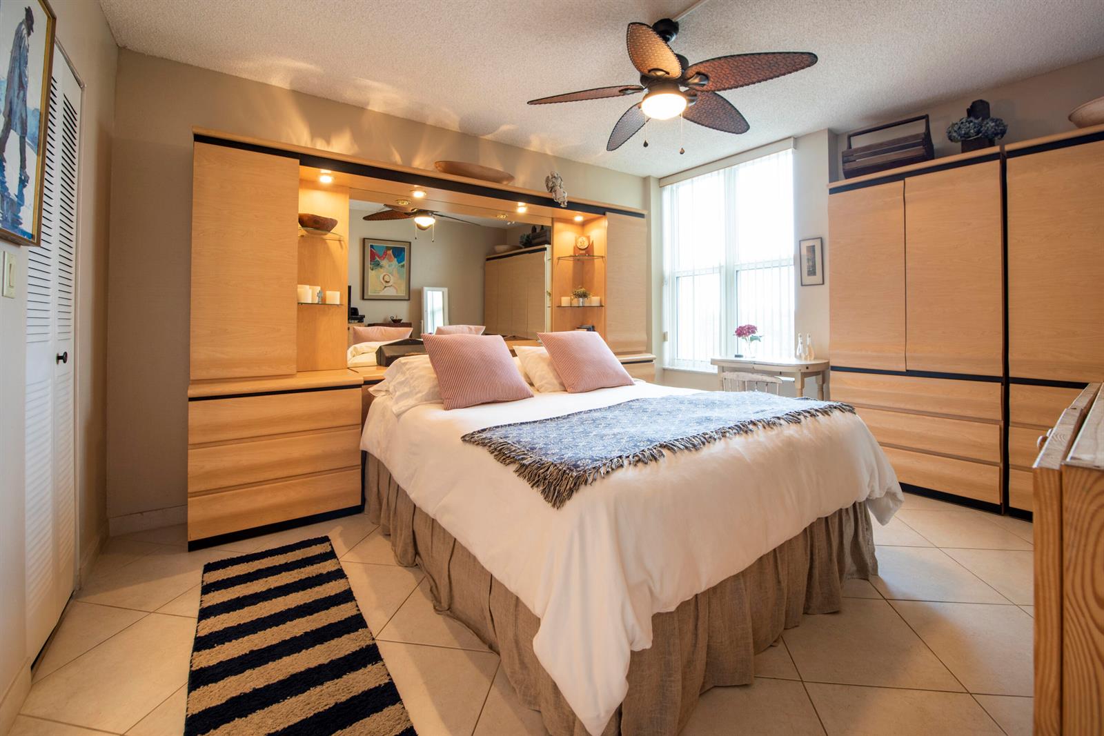 A bedroom features a queen bed, light wood cabinetry, a ceiling fan, and tiled floors — 1391 S Ocean Boulevard # 308, Pompano Beach FL 33062, POMPANO BEACH, FL