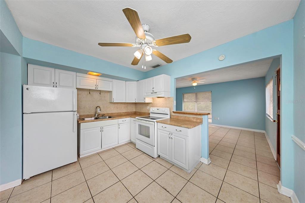 A kitchen with white cabinets, white appliances, and light blue walls over tiled floors — 5326 BERKLEY ROAD, NEW PORT RICHEY, FL