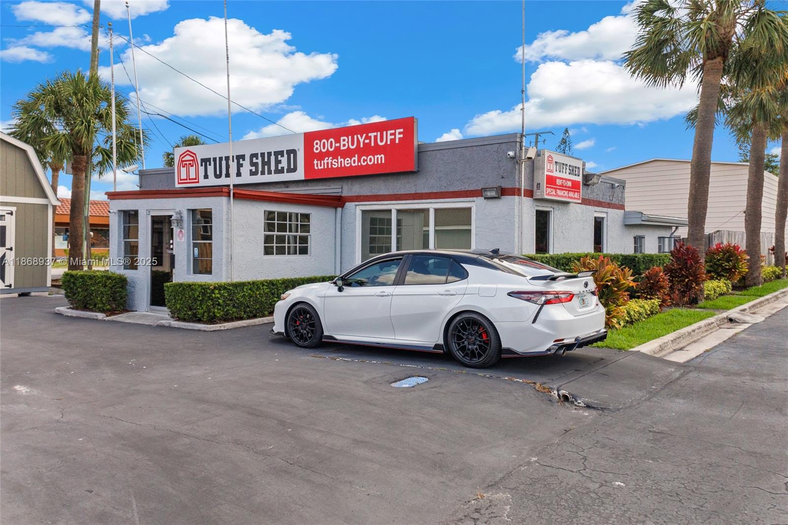 A white sedan is parked in front of a Tuff Shed commercial building with palm trees — 2402 S US HWY 1, Fort Pierce FL 34982, FORT PIERCE, FL