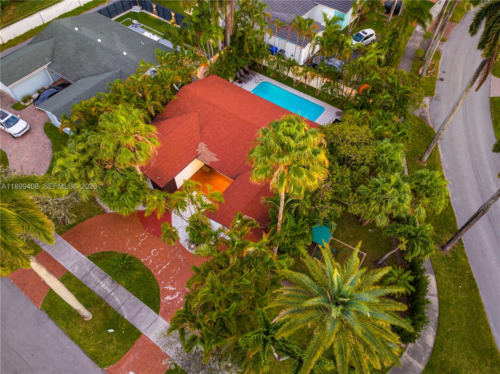 An aerial view shows a house with a red roof, a swimming pool, and palm trees — 1244 Garfield St, Hollywood FL 33019, HOLLYWOOD, FL