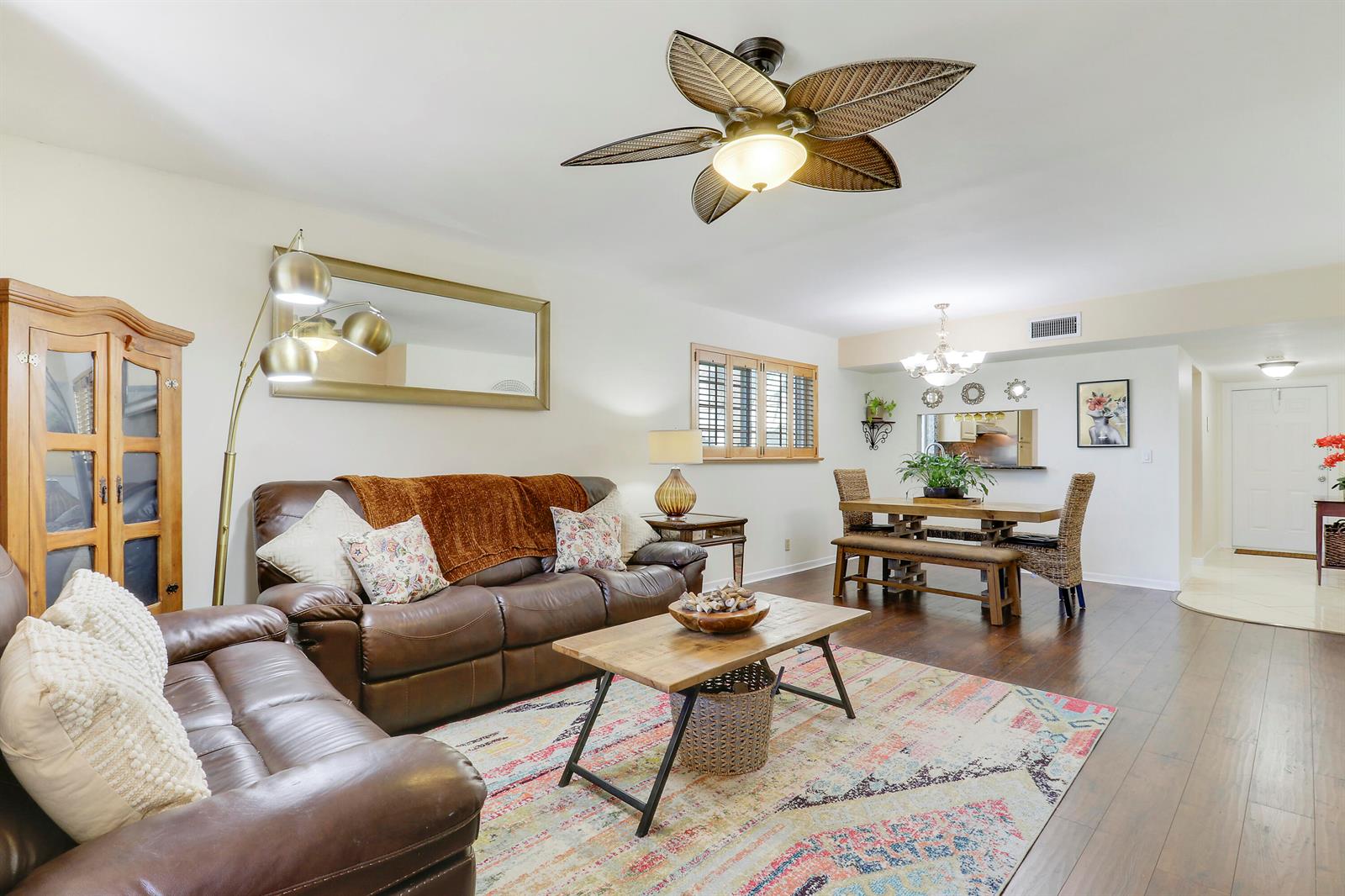 A living room with brown leather sofas, a wooden coffee table, and a dining area — 1700 Dover Road # 106a, Delray Beach FL 33445, DELRAY BEACH, FL