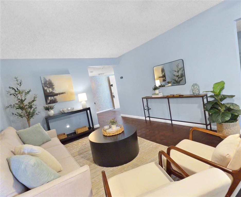 A living room features light blue walls, a sofa, two armchairs, and two console tables — 553 FAIRWAYS CIRCLE UNIT B, OCALA, FL