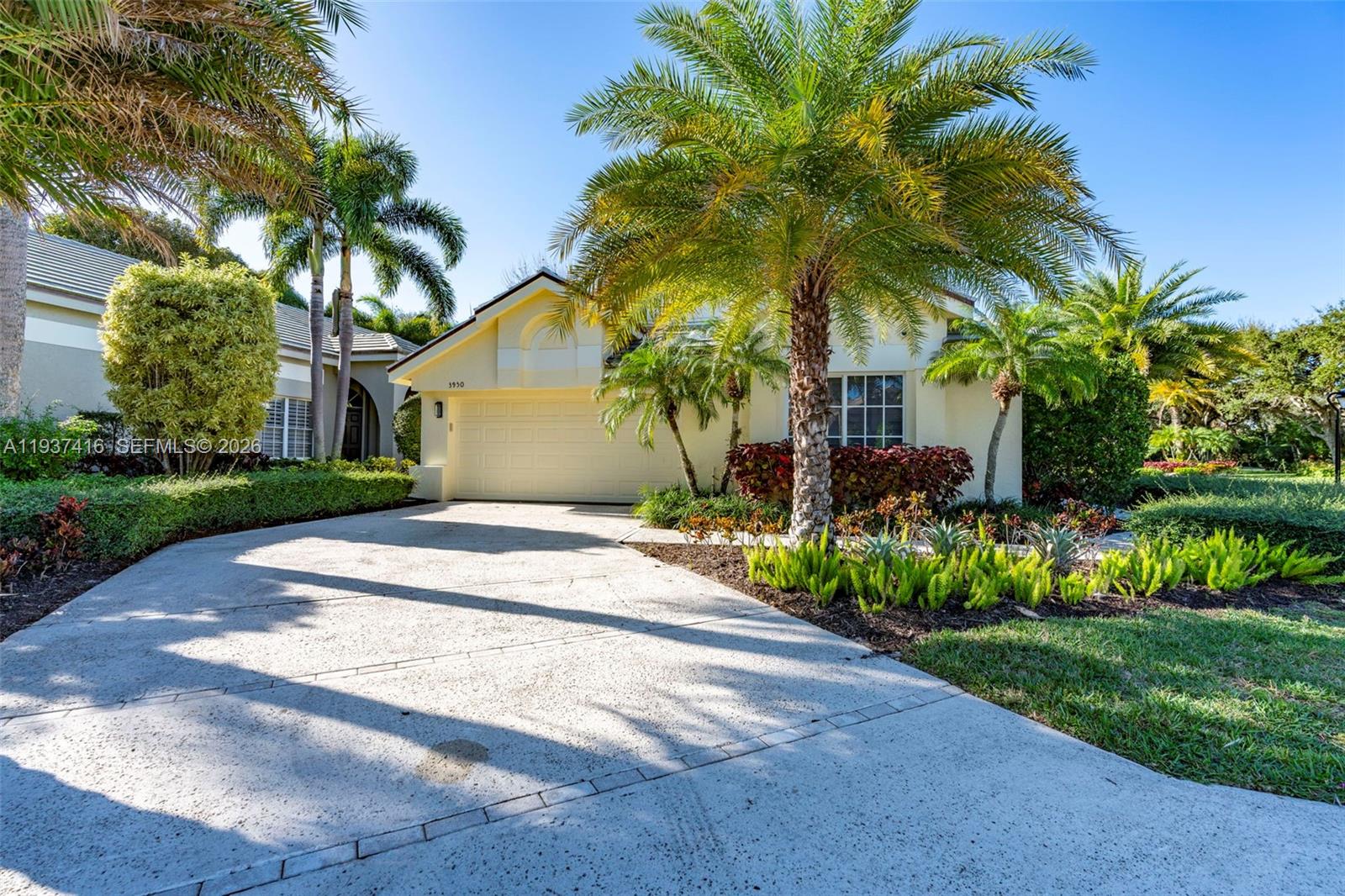 A single-story house with a beige exterior, a two-car garage, and palm trees in front — 3950 Shearwater Dr, Jupiter FL 33477, JUPITER, FL