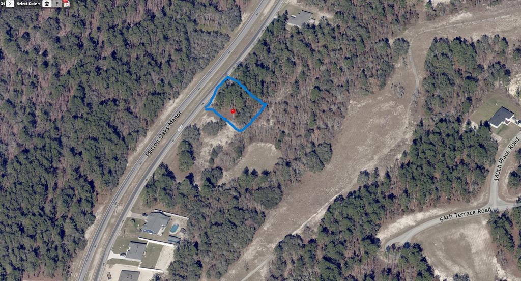 This aerial map shows a vacant, wooded lot outlined in blue near a road — MARION OAKS MANOR UNIT 9, OCALA, FL