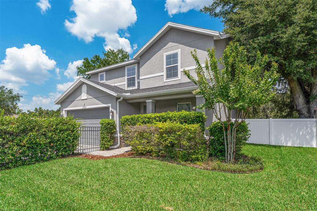 A two-story gray house with a garage, front porch, and manicured hedges on a lawn — 4723 CONWAY ROAD, ORLANDO, FL
