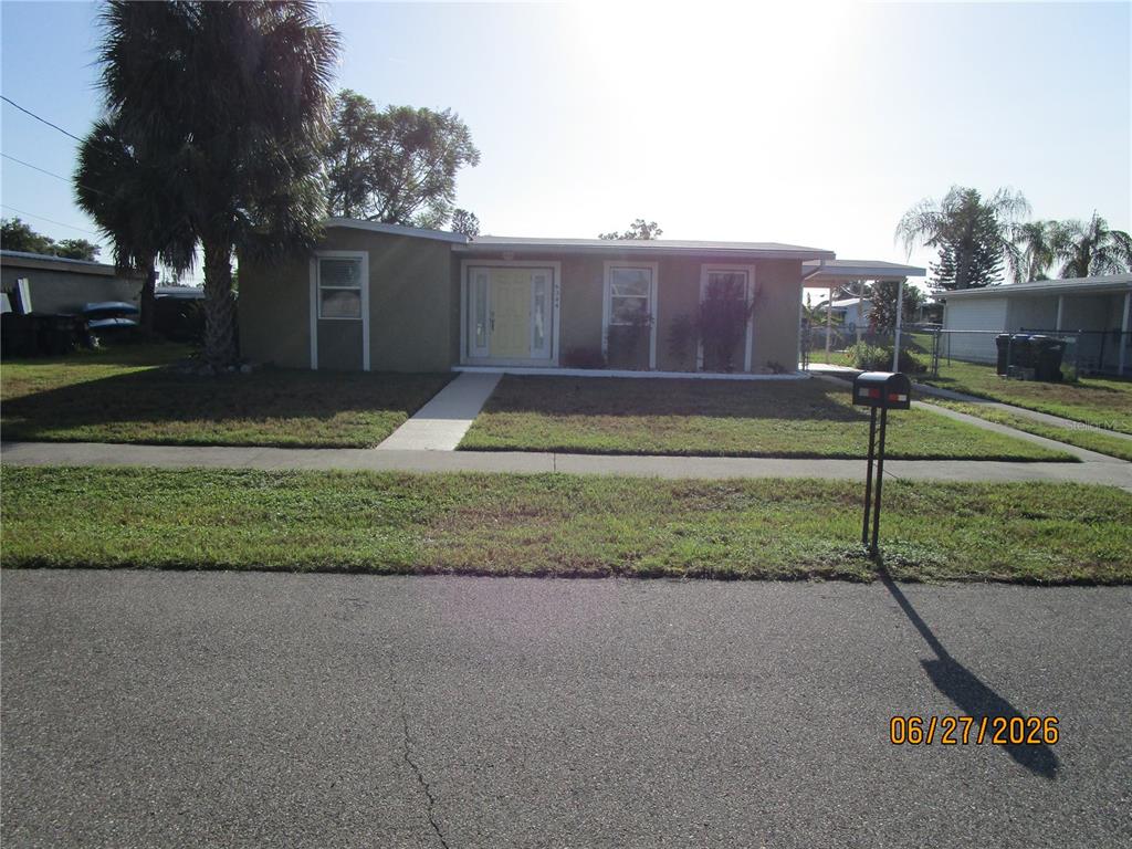 A single-story house with a light-colored exterior, a front walkway, and a palm tree — 6344 MATARO COURT, NORTH PORT, FL