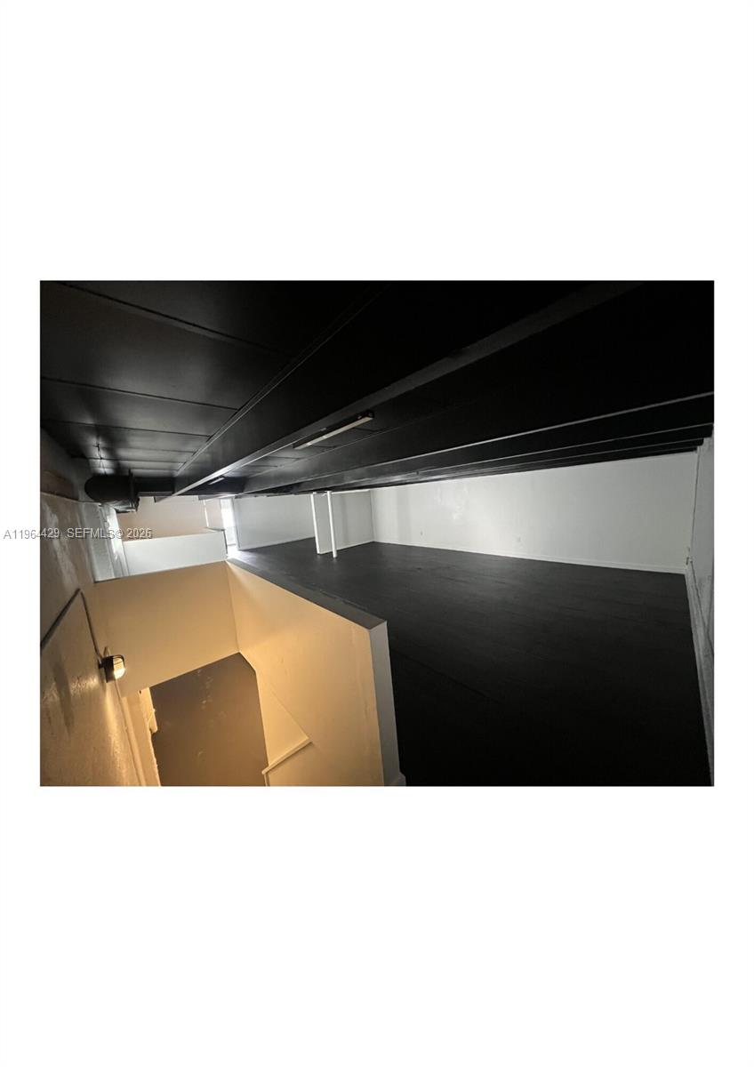 A loft area features dark wood flooring, a black ceiling, and white walls — 1155 SW 6th St, Miami FL 33130, MIAMI, FL