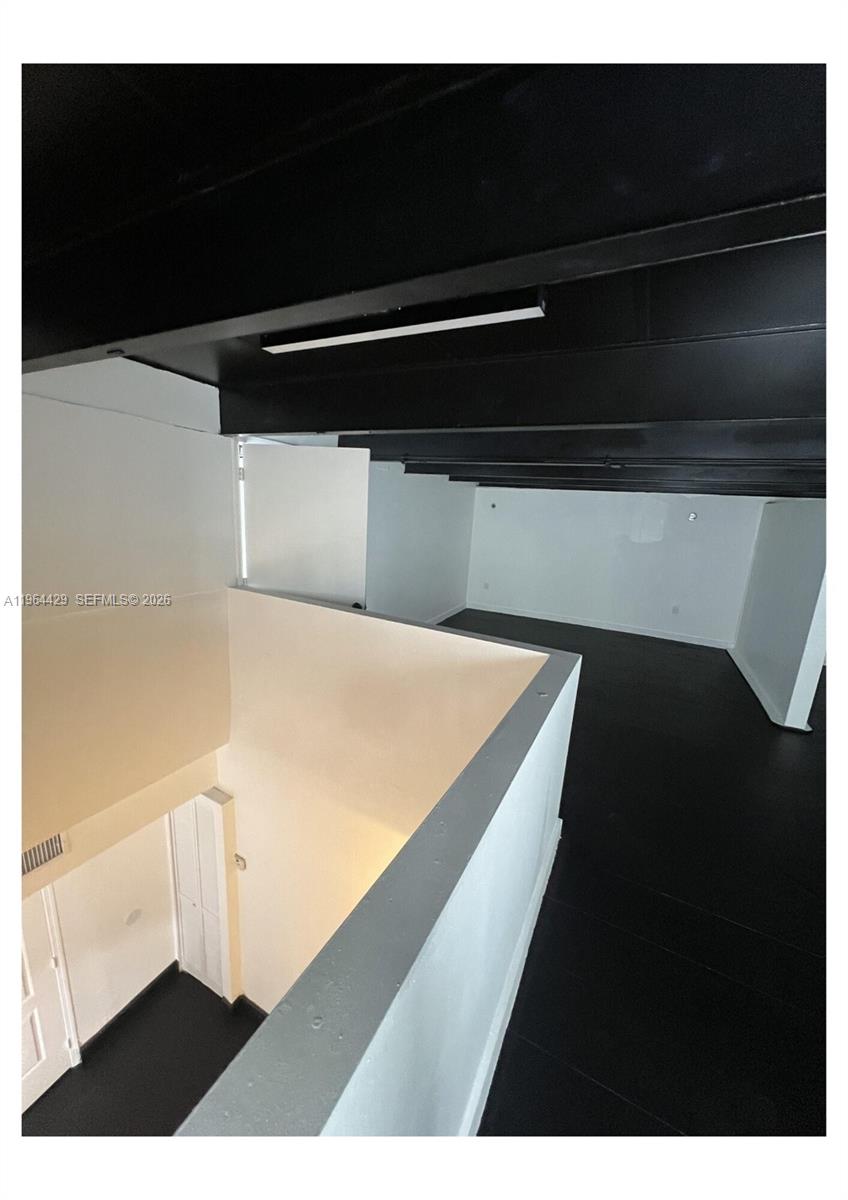 An interior view shows a lofted space with black ceilings and floors overlooking a lower level — 1155 SW 6th St, Miami FL 33130, MIAMI, FL