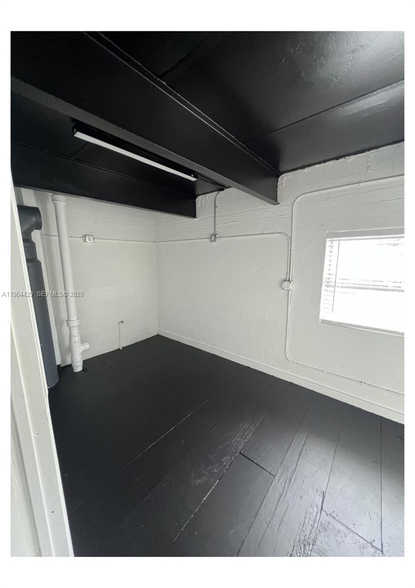 An empty room features black painted floors, a black ceiling, and white brick walls — 1155 SW 6th St, Miami FL 33130, MIAMI, FL