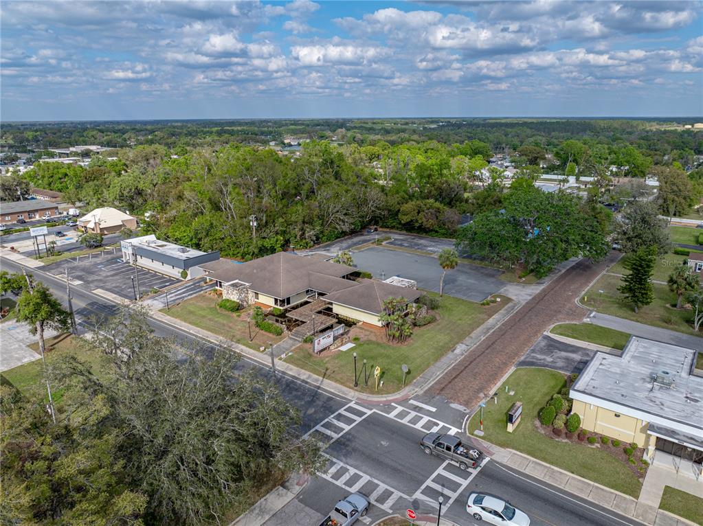 An aerial view shows a commercial building with a parking lot at a street intersection — 13924 7TH STREET, DADE CITY, FL