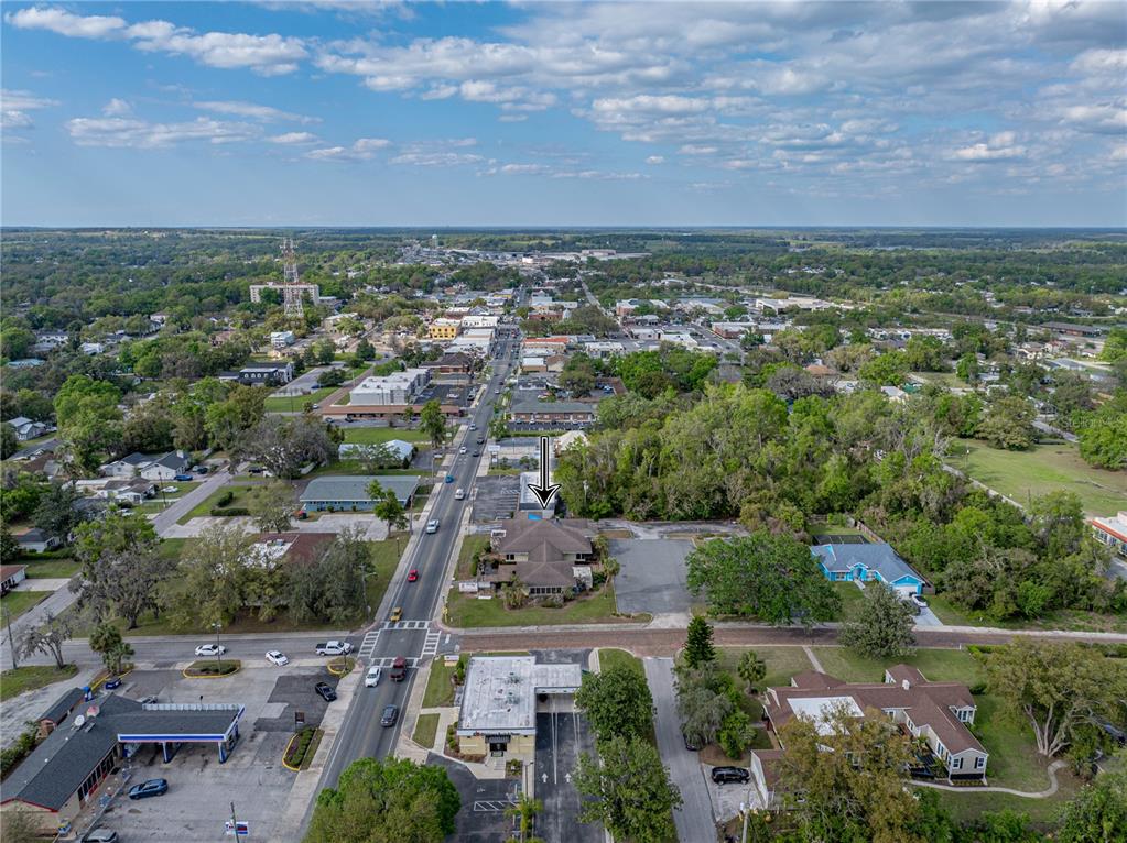 An aerial view shows a commercial building with a parking lot along a main road — 13924 7TH STREET, DADE CITY, FL