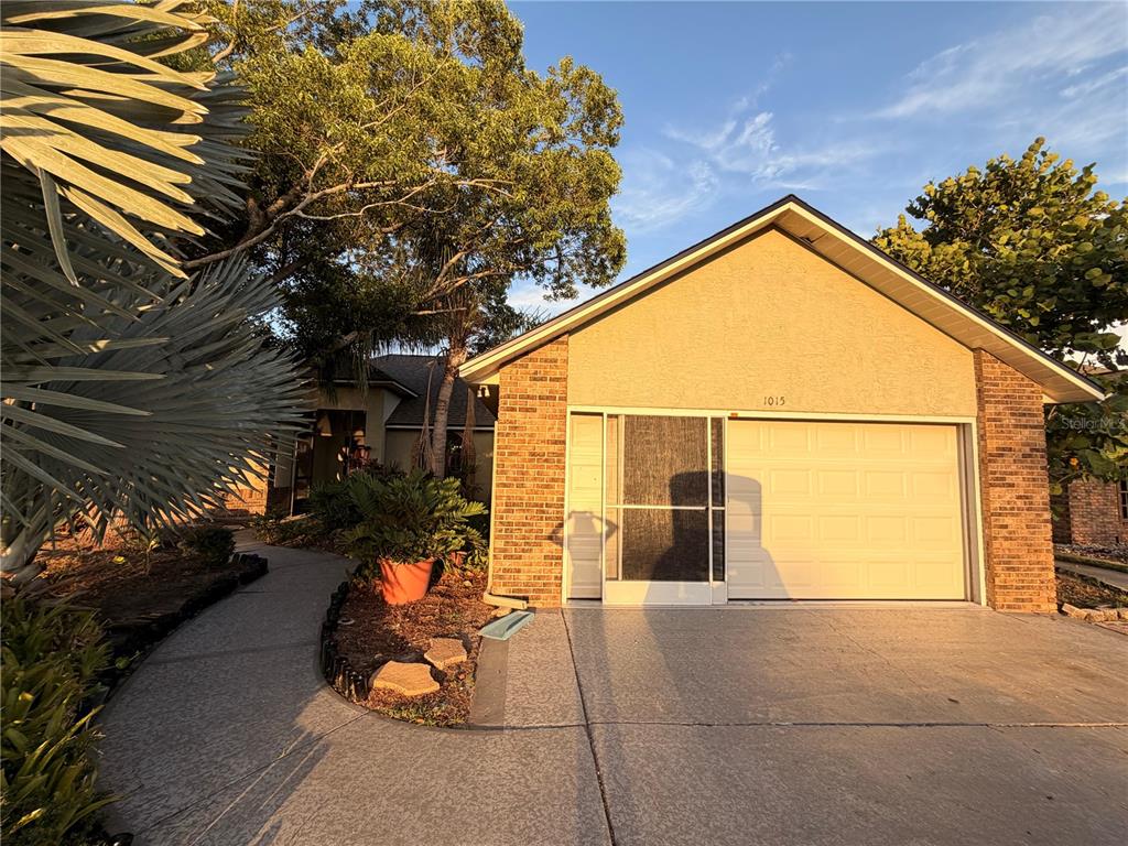 A single-story house with a brick and stucco facade, a garage, and a paved walkway — 1015 CALLE ROSA PLACE, SUN CITY CENTER, FL
