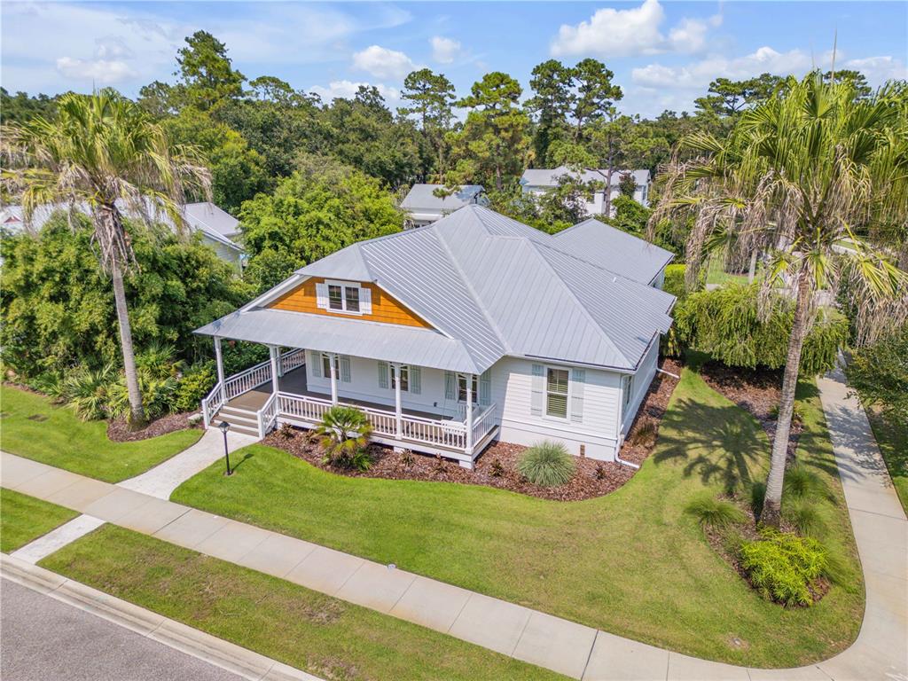 An aerial view shows a white house with a metal roof and a wrap-around porch — 1902 KINGS, NEW SMYRNA BEACH, FL