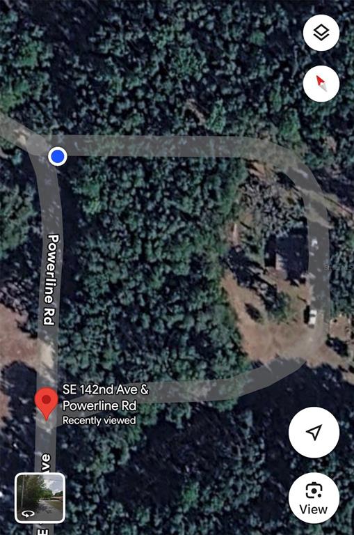 This is a satellite map view showing a wooded lot at a road intersection — SE 142ND AVE AND SE 120TH PL, OCKLAWAHA, FL