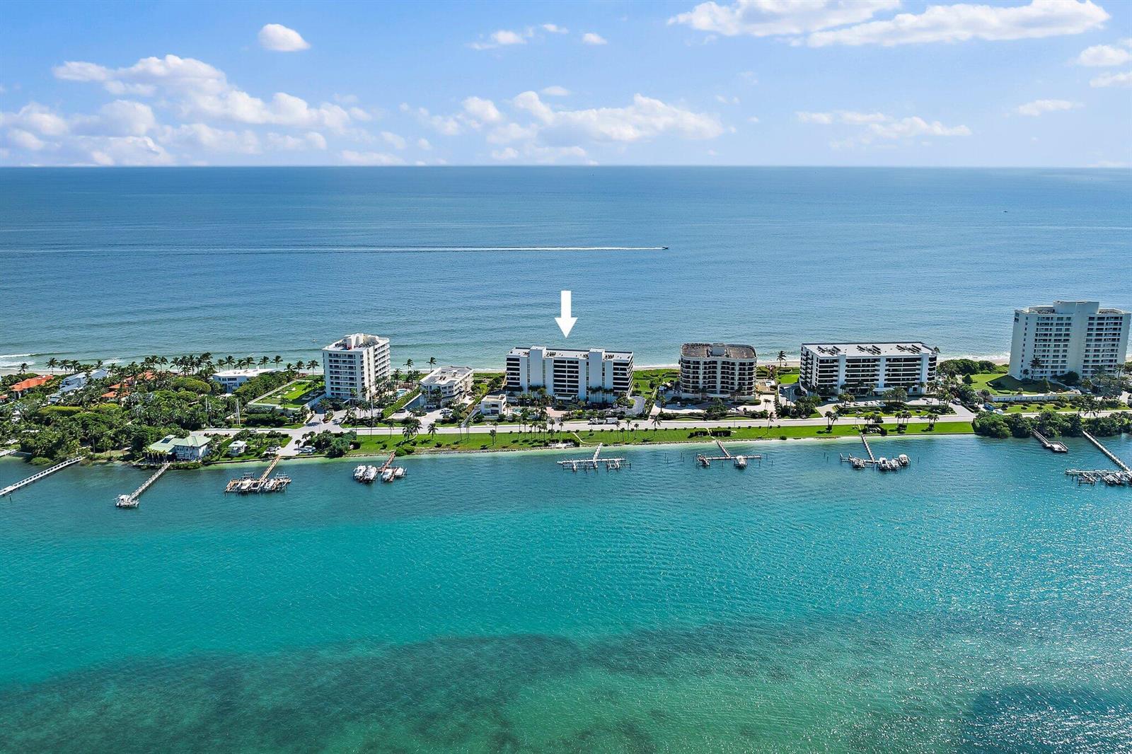 An aerial view shows a multi-story beachfront condominium building marked by a white arrow — 19900 Beach Road # 201, Jupiter FL 33469, JUPITER, FL