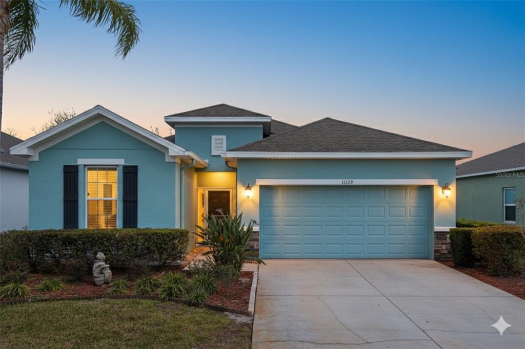 A single-story teal house with a two-car garage and a front yard with landscaping — 11129 KISKADEE CIRCLE, NEW PORT RICHEY, FL