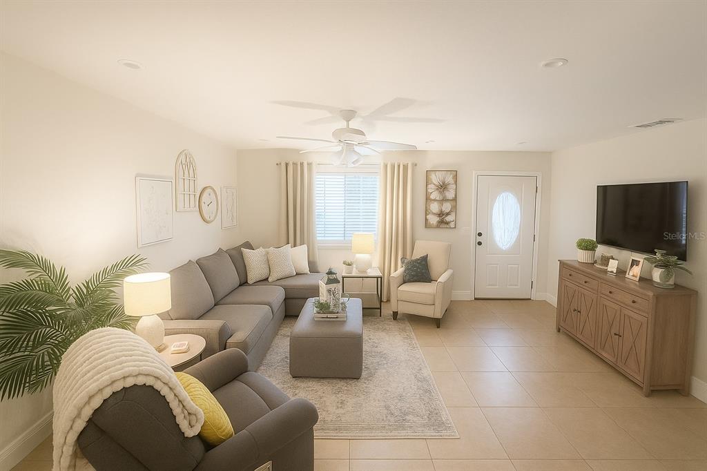A living room features a gray sectional sofa, an armchair, and a television on a console — 5120 CHAVES CIRCLE, PORT CHARLOTTE, FL