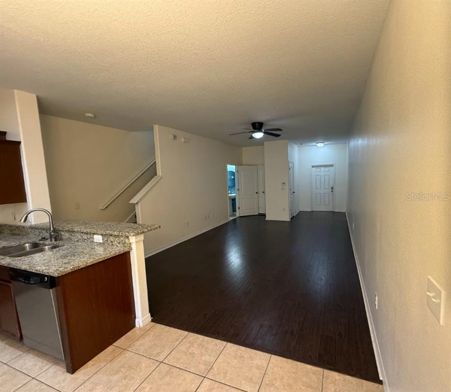 A view from a kitchen with granite countertops looking into an open-concept living area — 2807 LANTERN HILL AVENUE, BRANDON, FL