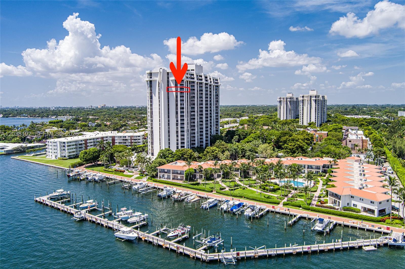 An aerial view shows a tall residential high-rise building situated next to a boat marina — 4000 Towerside Ter # 1701, Miami FL 33138, MIAMI, FL
