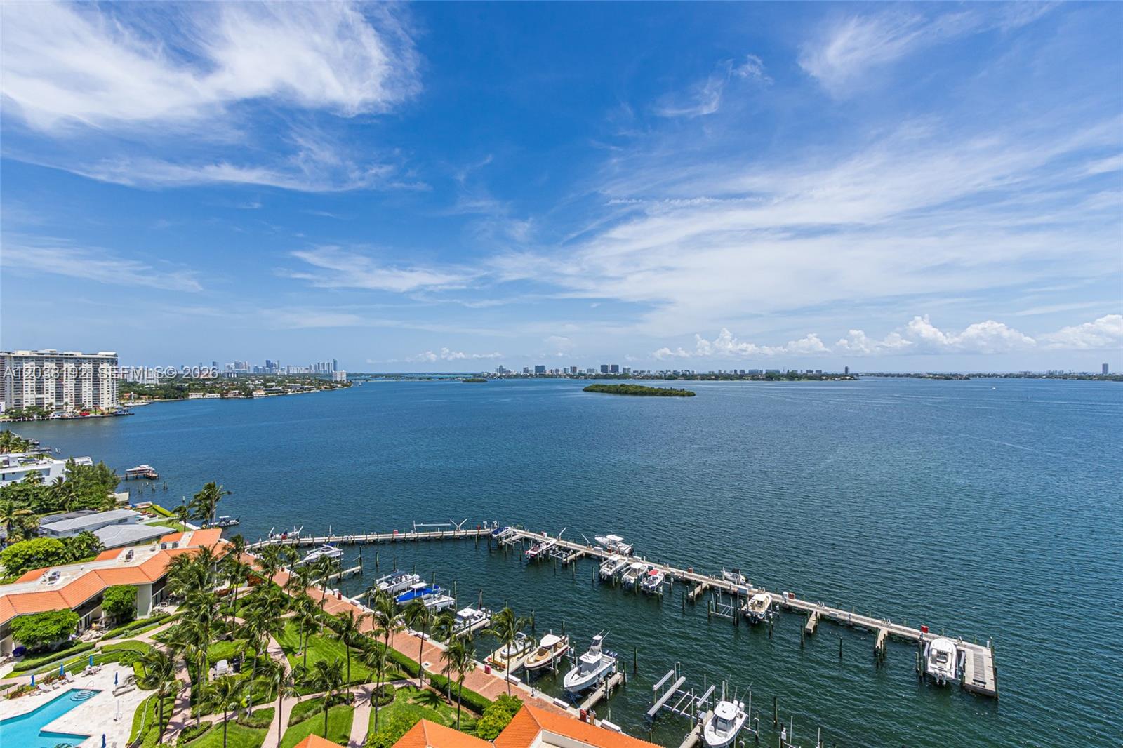 An aerial view shows a marina with docked boats, a grassy park, and a large bay — 4000 Towerside Ter # 1701, Miami FL 33138, MIAMI, FL