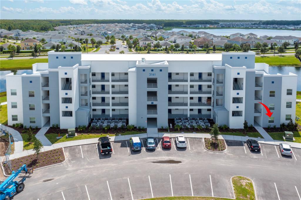 An exterior view shows a multi-story apartment building with a red arrow pointing to a ground-floor unit — 3161 PARADOX CIRCLE UNIT # 108, KISSIMMEE, FL