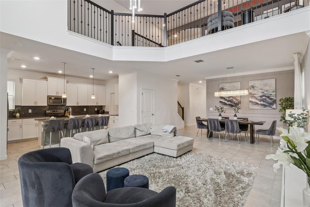 An open-concept living area with a kitchen, dining space, and a high-ceilinged loft above — 9095 SOMMERSET HILLS DRIVE, DAVENPORT, FL