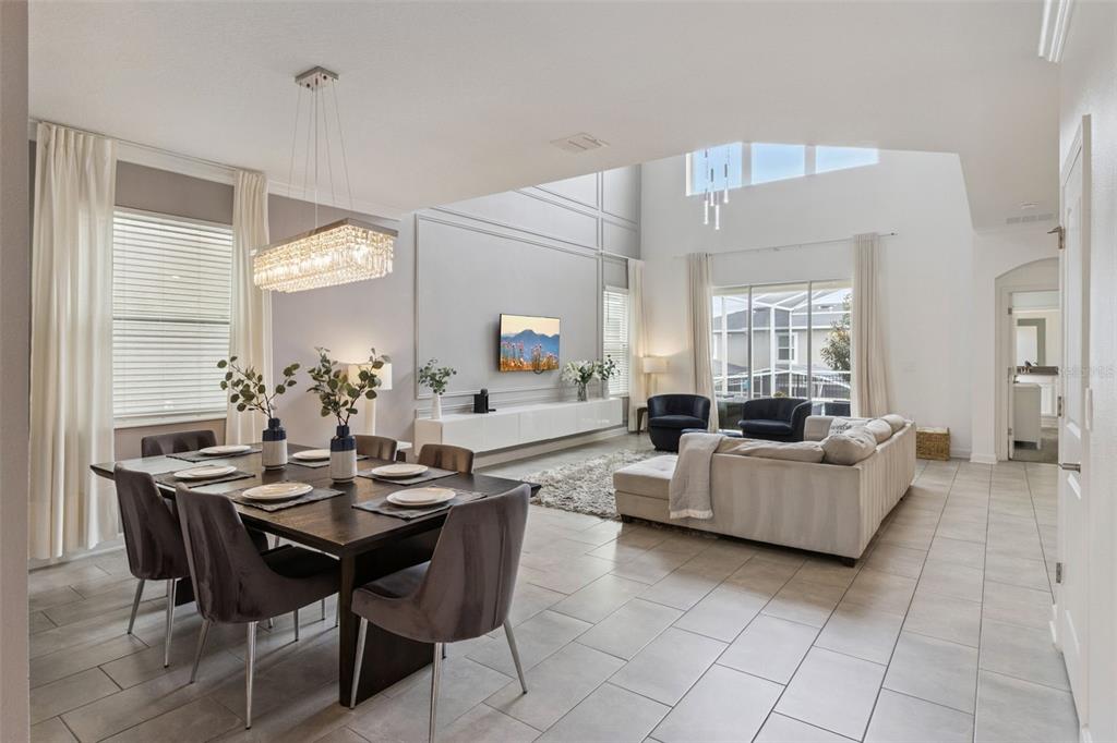 A dining area and living room share an open-concept space with high ceilings and tile floors — 9095 SOMMERSET HILLS DRIVE, DAVENPORT, FL