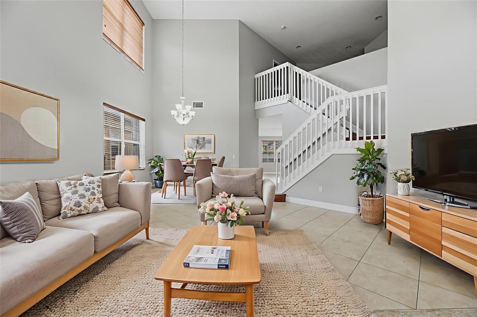 A living room with high ceilings, a staircase, tile flooring, and a dining area — 2332 SW 126th Avenue, Miramar FL 33027, MIRAMAR, FL