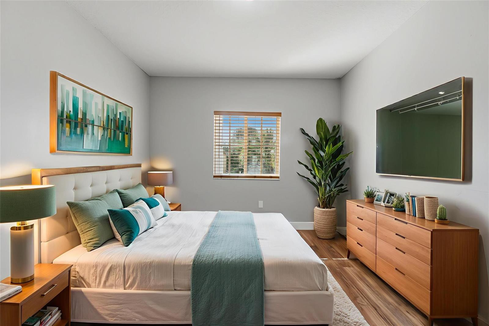 A bedroom features a bed with teal accents, a wooden dresser, and a wall-mounted television — 2332 SW 126th Avenue, Miramar FL 33027, MIRAMAR, FL