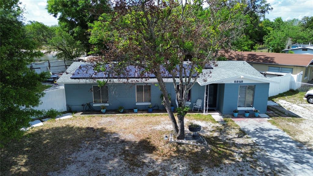 An aerial view of a single-story blue house with solar panels on the roof — 5828 HARCOURT AVENUE, ORLANDO, FL