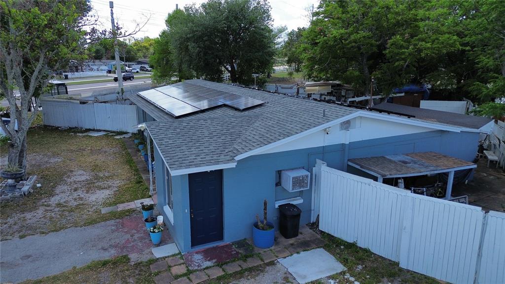 An aerial view of a blue house with a shingled roof and solar panels — 5828 HARCOURT AVENUE, ORLANDO, FL
