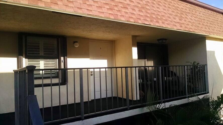 An exterior view of a balcony with a white door, a window, and metal railings — 120 N M Street # L, FL 33460, FL