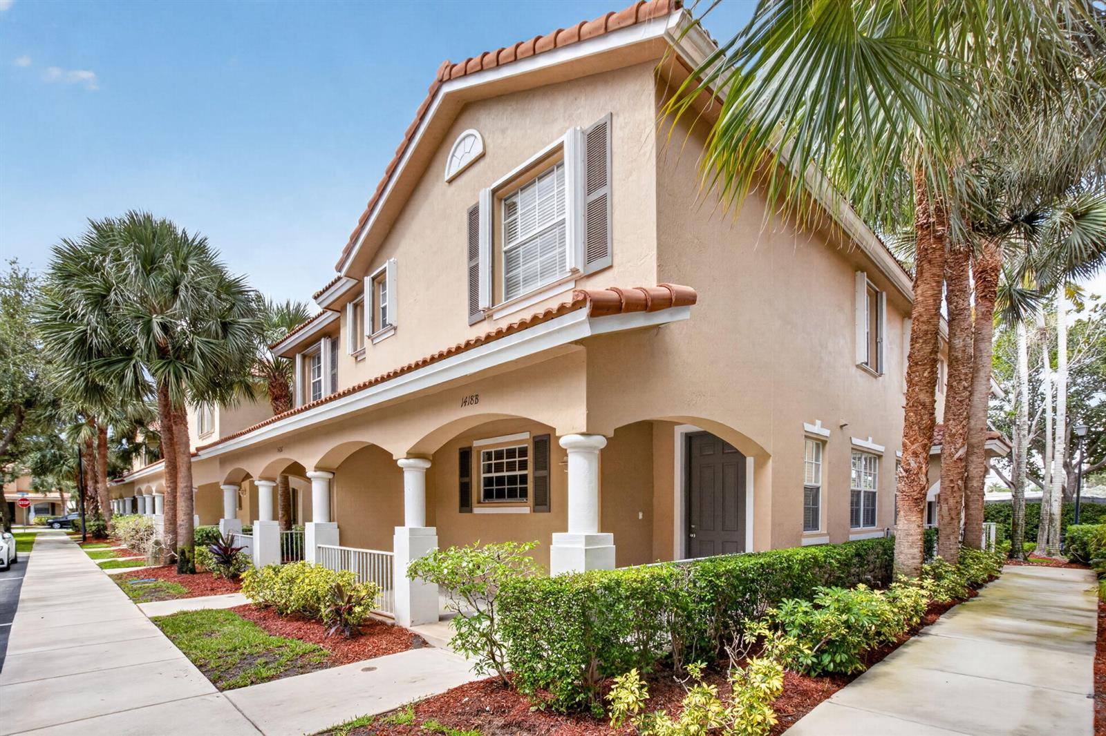 A two-story tan stucco townhouse with a covered front porch and arched columns — 1418 W Wickham Circle # B, Delray Beach FL 33445, DELRAY BEACH, FL