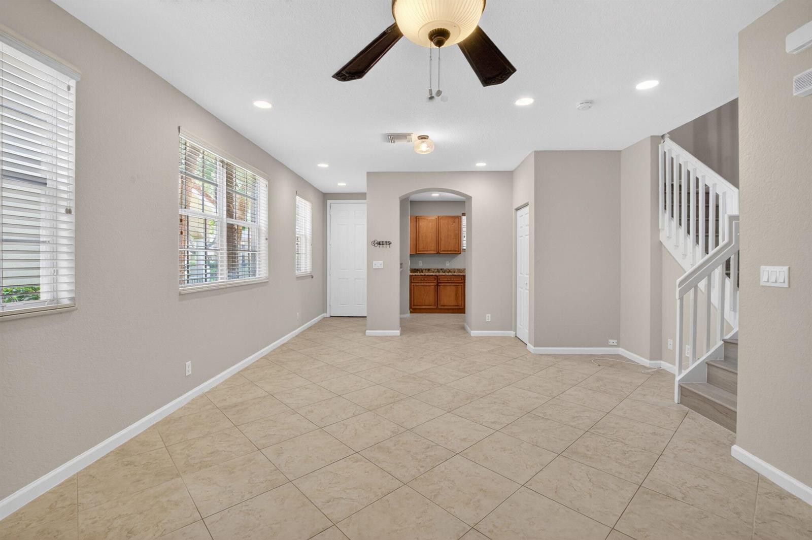 A living room with tile flooring, a ceiling fan, and a staircase leading upstairs — 1418 W Wickham Circle # B, Delray Beach FL 33445, DELRAY BEACH, FL