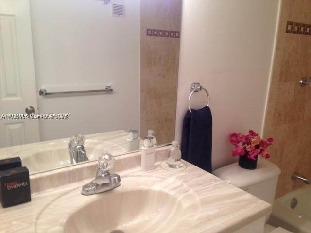 A bathroom features a marble vanity, a sink, a mirror, and a towel rack — 3910 Inverrary Blvd # B, Lauderhill FL 33319, LAUDERHILL, FL