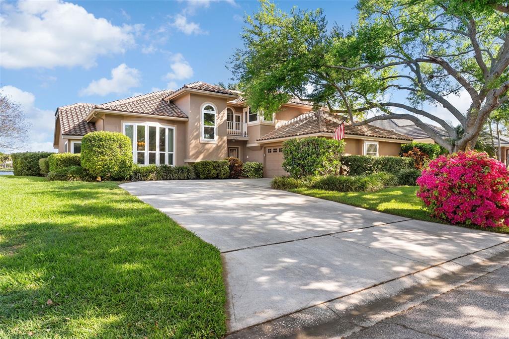 A two-story stucco house with a tile roof and a concrete driveway — 4731 COCONUT PALM CIRCLE NE, ST PETERSBURG, FL