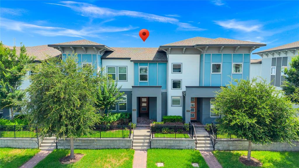 A multi-unit residential building with blue and white siding, a shingled roof, and front landscaping — 7381 ALPINE BUTTERFLY LANE, ORLANDO, FL