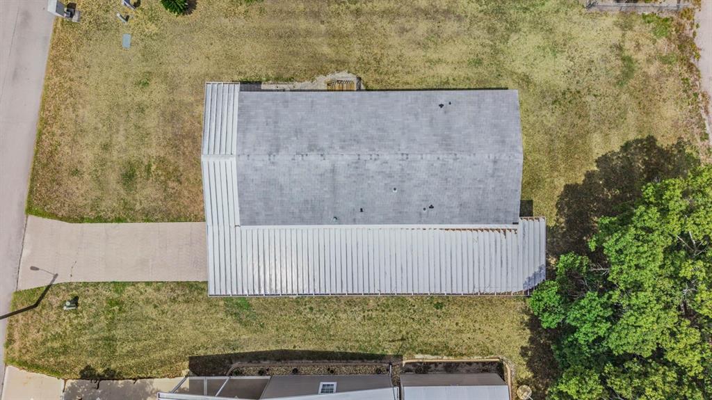 An aerial view shows a house with a shingled roof and a metal-roofed porch — 36747 LAKEWOOD DRIVE, ZEPHYRHILLS, FL