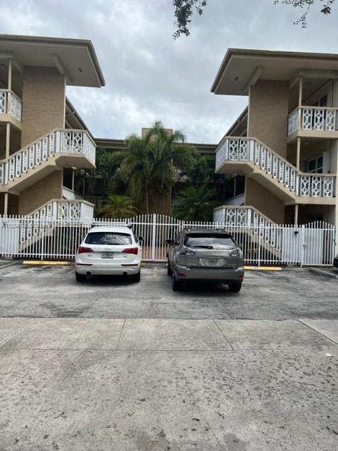 Two cars are parked in front of a two-story apartment building with exterior staircases — 1958 Monroe St # 208, Hollywood FL 33020, HOLLYWOOD, FL