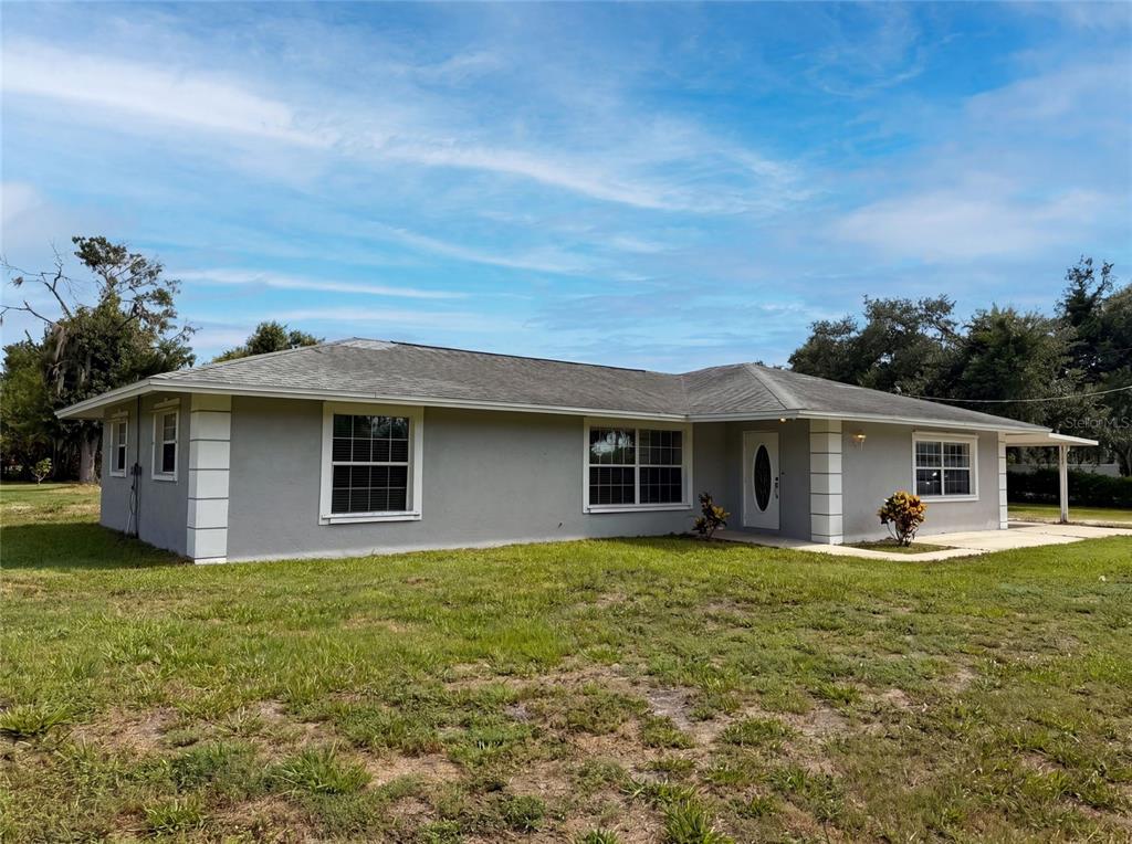 A single-story gray house with a white-trimmed front door and a grassy yard — 2805 105TH STREET E, PALMETTO, FL