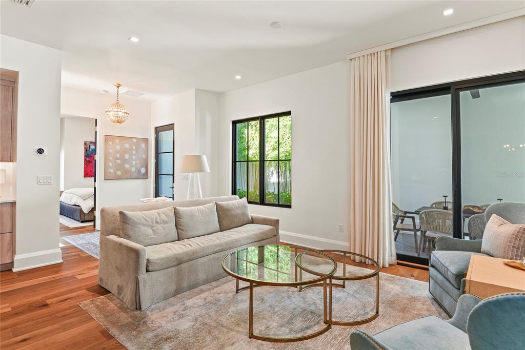 A living room features a beige sofa, glass coffee tables, and a sliding glass door — 1120 WISCONSIN AVENUE, WINTER PARK, FL